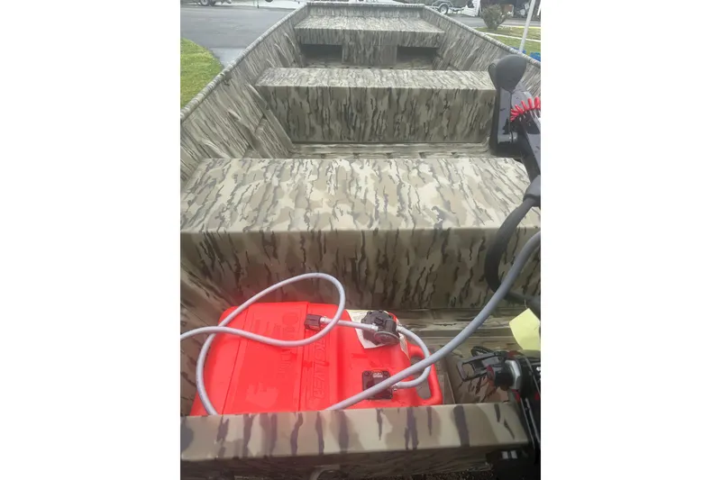 Slide: The Image of 2026 Smoker Craft 1448 Jon boat interior with camouflage design and red fuel tank. - 6