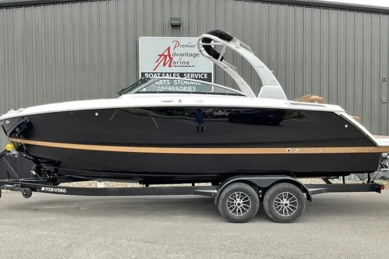 The Image of 2026 Four Winns H6 boat on trailer, sleek black design with modern features. - 0