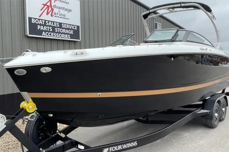 Slide: The Image of 2026 Four Winns H6 boat on trailer at marine dealership. - 1