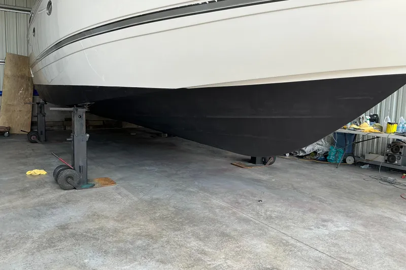 Slide: The Image of 2005 Cruisers Yachts 370 Express in dry dock, showcasing hull and maintenance setup. - 13