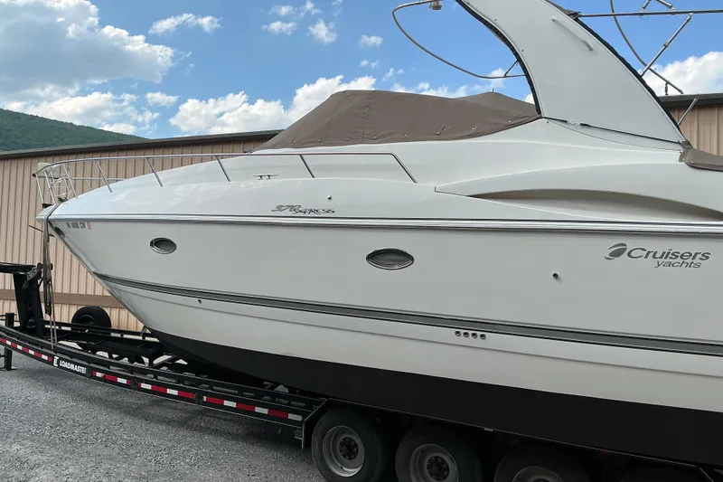 Slide: The Image of 2005 Cruisers Yachts 370 Express on trailer, parked outdoors under blue sky. - 7