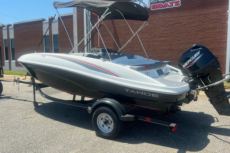 Slide: The Image of 2023 Tahoe T16 boat with Mercury engine on trailer, parked outside a building. - 4