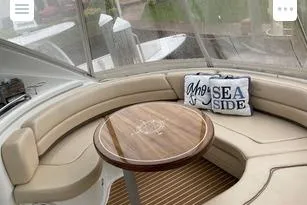 Slide: The Image of 2008 Cruisers Yachts 560 Express interior with cushioned seating and decorative pillows. - 10