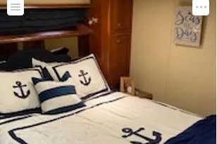 Slide: The Image of 2008 Cruisers Yachts 560 Express cabin with nautical-themed bedding and decor. - 11