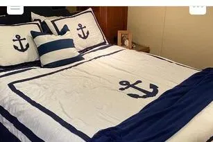 Slide: The Image of Nautical-themed bedding with anchor designs on a 2008 Cruisers Yachts 560 Express. - 13