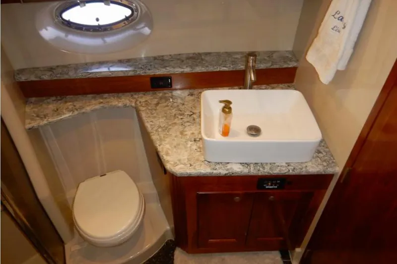 Slide: The Image of Luxurious bathroom in 2008 Cruisers Yachts 560 Express with marble countertop and modern fixtures. - 16
