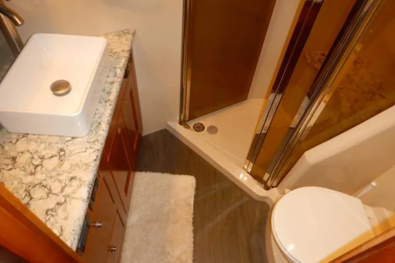 Slide: The Image of Luxurious bathroom in 2008 Cruisers Yachts 560 Express with marble countertop and modern fixtures. - 18