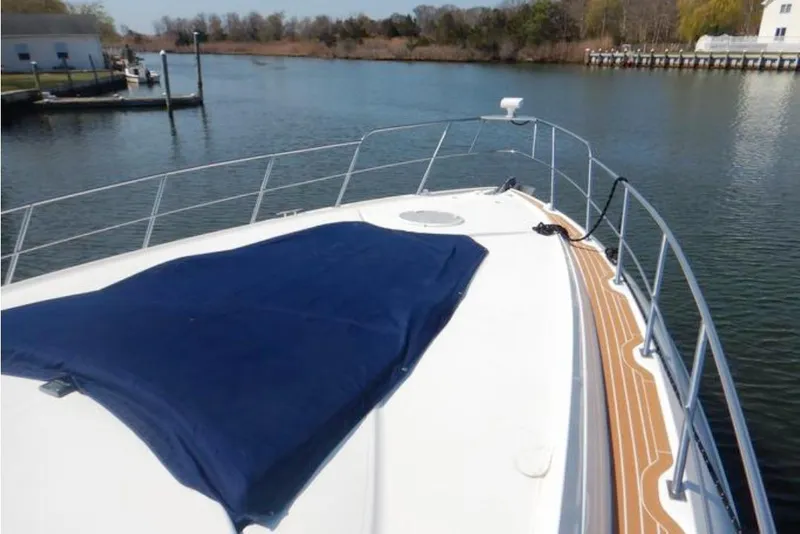 Slide: The Image of 2008 Cruisers Yachts 560 Express bow view on calm water, featuring sleek design. - 3