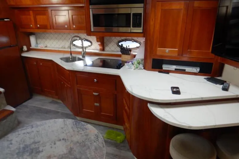 Slide: The Image of Luxurious 2008 Cruisers Yachts 560 Express kitchen with wood cabinetry and modern appliances. - 8