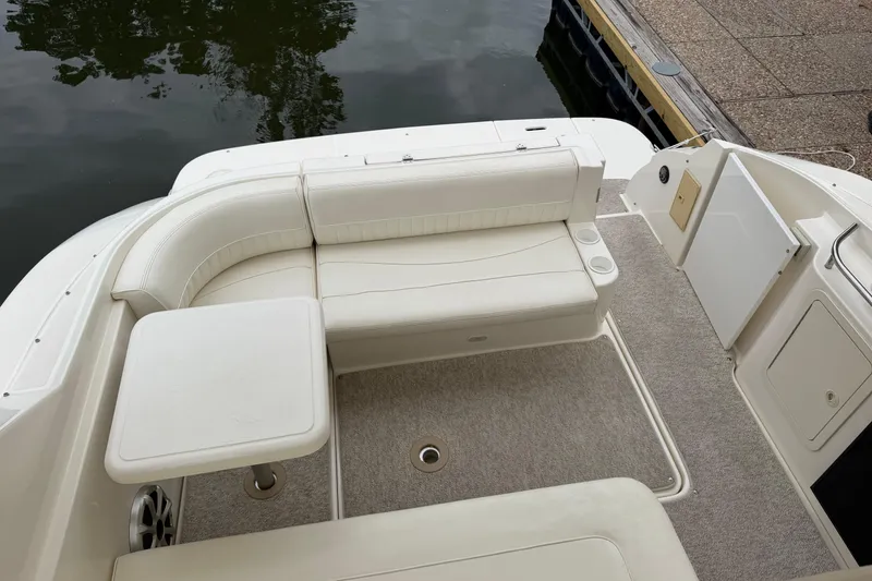 Slide: The Image of 2004 Cruisers Yachts 320 Express boat interior with white seating and table by the water. - 5