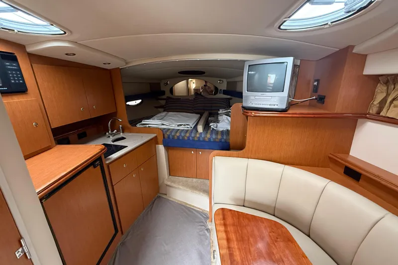 Slide: The Image of Interior of 2004 Cruisers Yachts 320 Express, featuring kitchenette, seating, and sleeping area. - 7