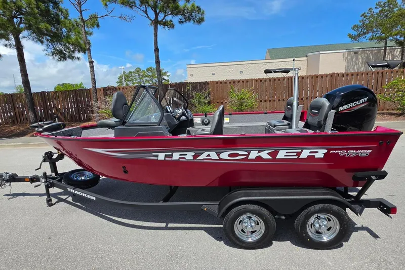 The Image of 2025 Tracker Pro Guide V-175 Combo boat on trailer, red exterior, parked outdoors. - 0