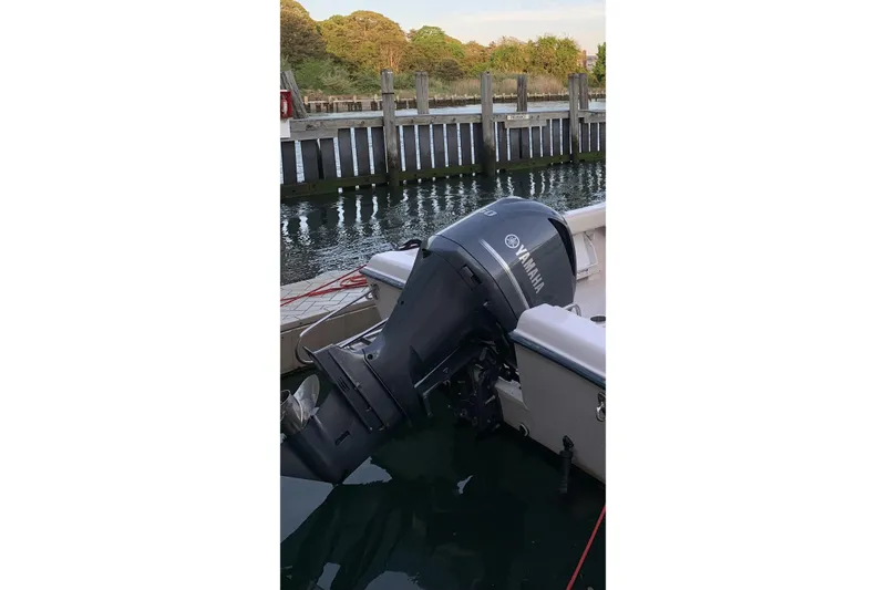 Slide: The Image of Outboard motor on a 2001 Grady-White Seafarer 226 boat docked by a pier. - 8