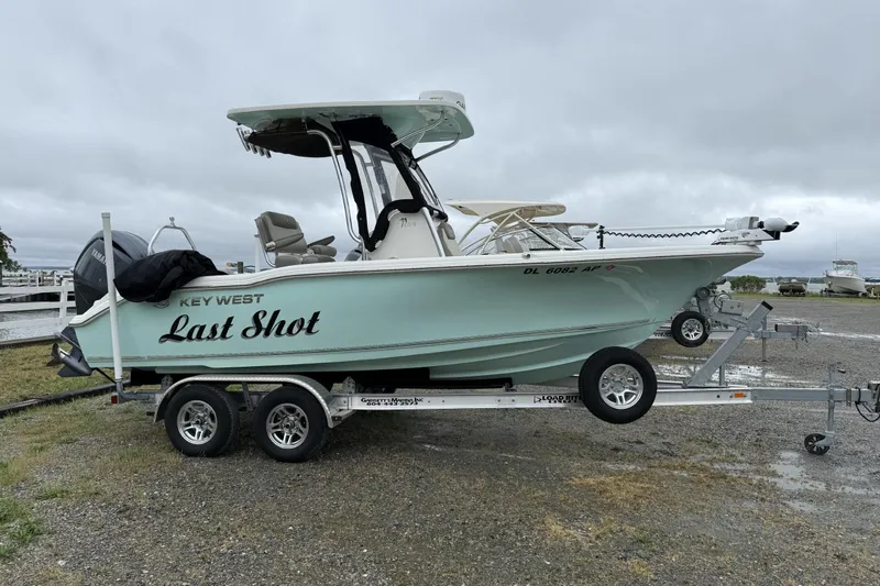 The Image of 2023 Key West 219 FS boat named "Last Shot" on a trailer, overcast sky. - 0