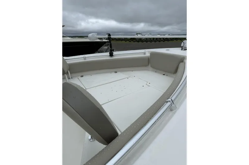 Slide: The Image of 2023 Key West 219 FS boat interior with cushioned seating under cloudy skies. - 1