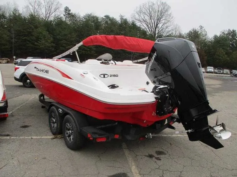 Slide: The Image of 2025 Tahoe 2150 OB boat with red canopy and outboard motor. - 2