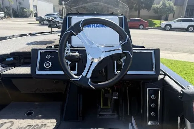 Slide: The Image of 2025 Ranger Z521R Cup-Equipped boat dashboard with steering wheel and control panels. - 11