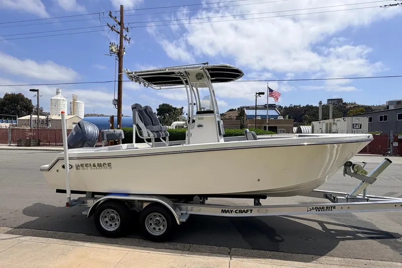 Slide: The Image of 2026 Defiance Catalina 210 boat on trailer, parked outdoors under a partly cloudy sky. - 16