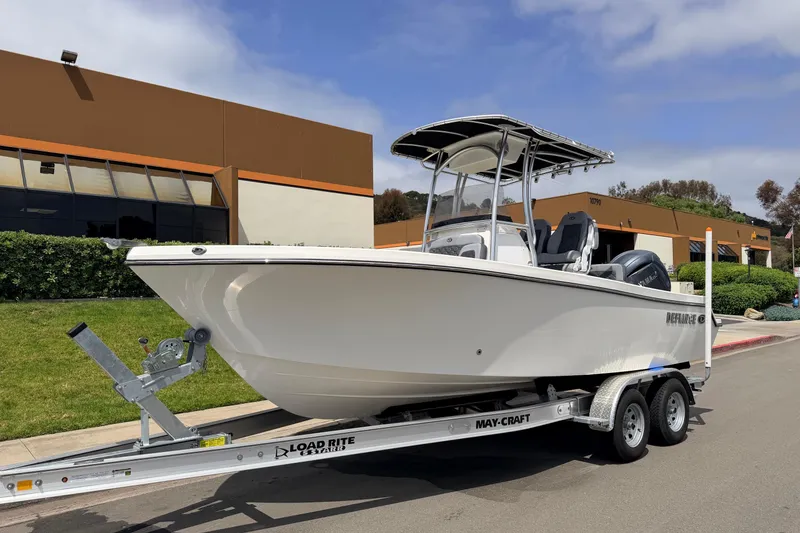 Slide: The Image of 2026 Defiance Catalina 210 boat on trailer, parked outside a commercial building. - 3