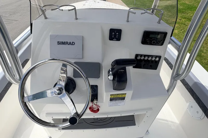 Slide: The Image of 2026 Defiance Catalina 210 boat console with steering wheel, Simrad display, and Yamaha controls. - 32