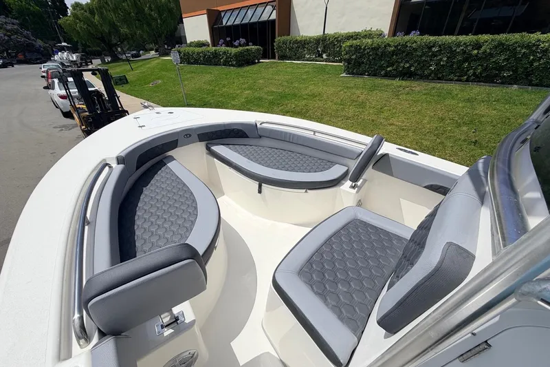 Slide: The Image of 2026 Defiance Catalina 210 boat with cushioned seating, parked outdoors. - 46