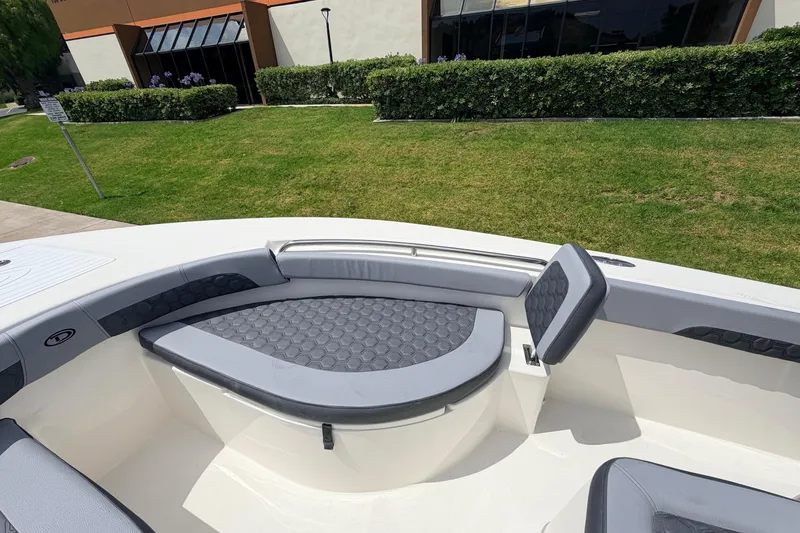 Slide: The Image of 2026 Defiance Catalina 210 boat interior with cushioned seating, parked near a building. - 50