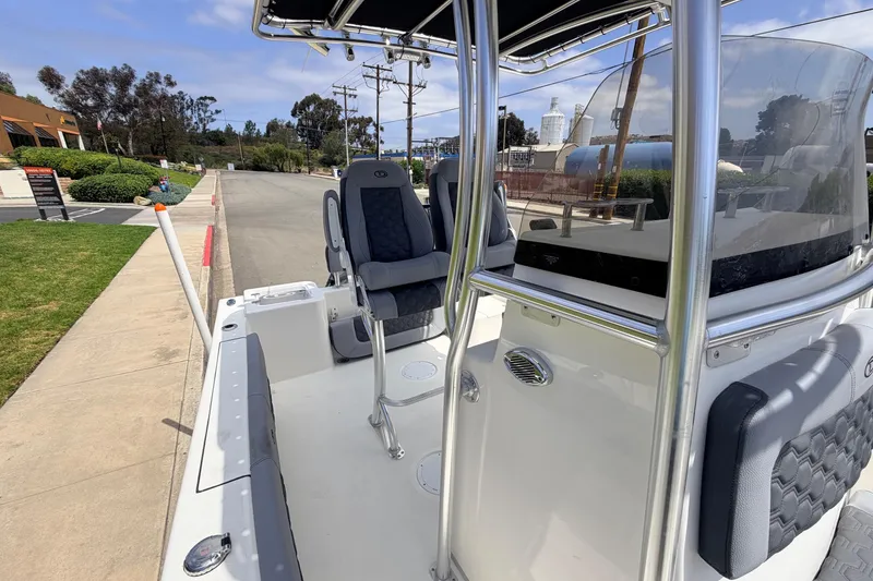 Slide: The Image of 2026 Defiance Catalina 210 boat interior with seating and console, parked outdoors. - 55