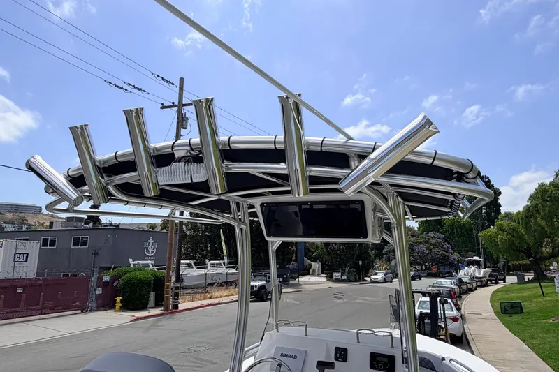 Slide: The Image of 2026 Defiance Catalina 210 boat with stainless steel rod holders and canopy, parked on a street. - 58