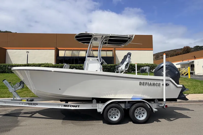 Slide: The Image of 2026 Defiance Catalina 210 boat on trailer, parked outdoors near industrial building. - 6
