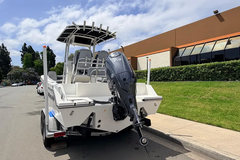 Slide: The Image of 2026 Defiance Catalina 210 boat on trailer, parked on street with outboard motor. - 9