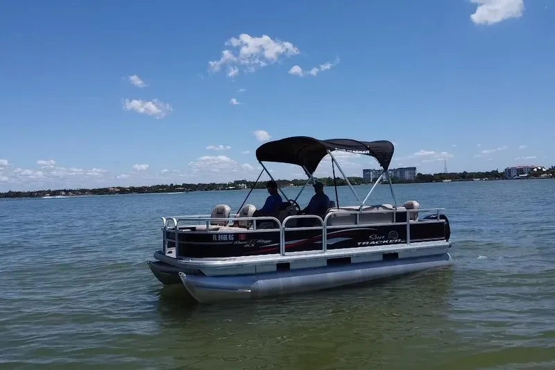 Slide: The Image of 2017 Sun Tracker Bass Buggy 18 DLX pontoon boat cruising on a sunny lake. - 19