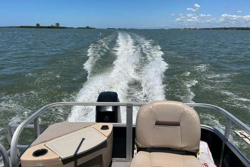 Slide: The Image of 2017 Sun Tracker Bass Buggy 18 DLX cruising on open water, leaving a wake trail. - 21
