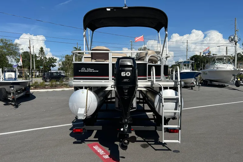 Slide: The Image of 2017 Sun Tracker Bass Buggy 18 DLX pontoon boat with Mercury 60 HP engine, parked outdoors. - 3