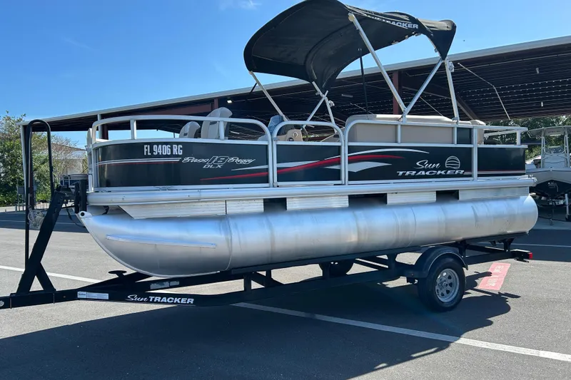 Slide: The Image of 2017 Sun Tracker Bass Buggy 18 DLX pontoon boat on trailer in parking lot. - 5