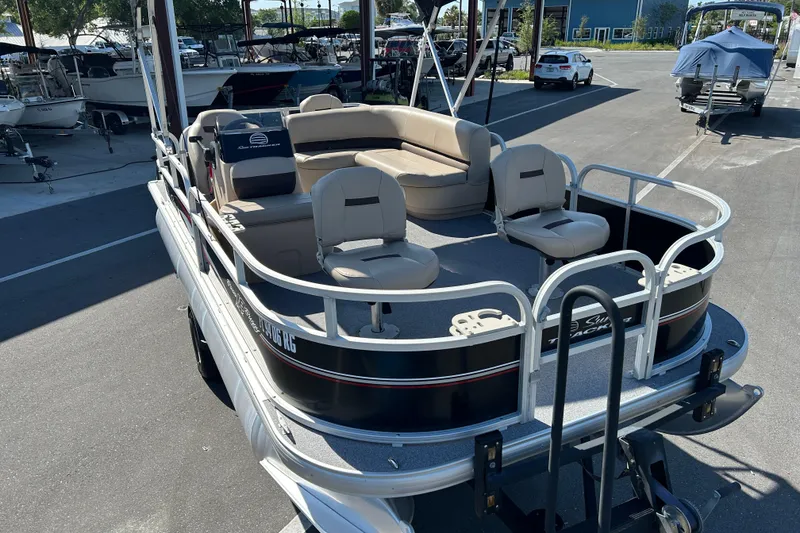 Slide: The Image of 2017 Sun Tracker Bass Buggy 18 DLX pontoon boat with beige seating in a marina. - 6