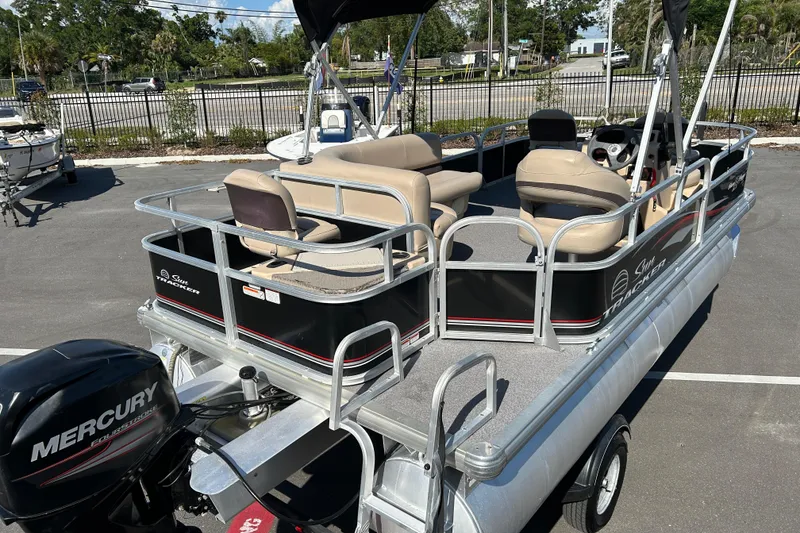 Slide: The Image of 2017 Sun Tracker Bass Buggy 18 DLX pontoon boat with Mercury engine, parked outdoors. - 7