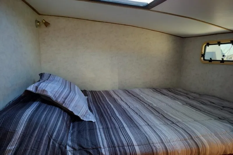 Slide: The Image of Cozy cabin interior of 2003 Custom Leopard Morrelli & Melvin 46 with striped bedding. - 16