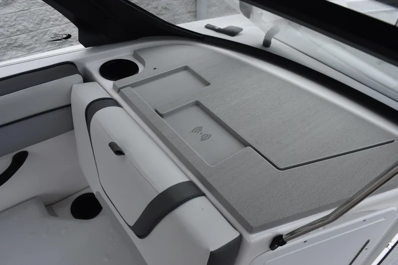 Slide: The Image of 2026 Yamaha Boats AR220 interior dashboard with wireless charging pad and cup holder. - 16