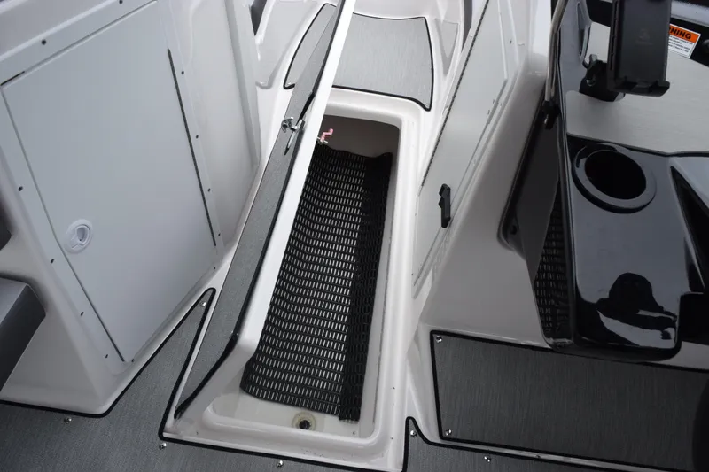 Slide: The Image of 2026 Yamaha Boats AR220 interior storage compartment with sleek design and black accents. - 18