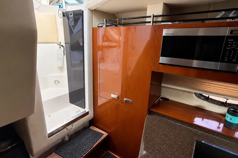 Slide: The Image of Interior of 2012 Sea Ray Sundancer 310 with shower, wooden cabinets, and microwave. - 6