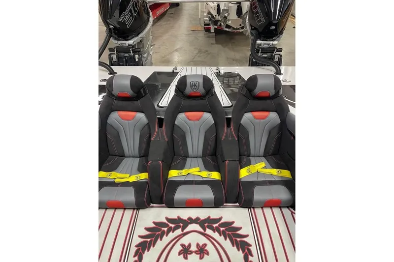 Slide: The Image of 2025 HellCat 32 Widebody boat seats with red and gray design, featuring yellow seatbelts. - 6