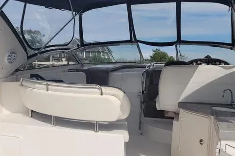 Slide: The Image of 2005 Regal Commodore 3560 IO boat interior with seating and helm, under a clear blue sky. - 1
