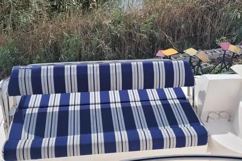 Slide: The Image of Striped seating on 2005 Regal Commodore 3560 IO boat, surrounded by lush greenery. - 14
