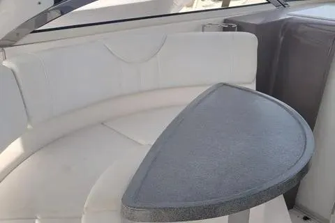 Slide: The Image of 2005 Regal Commodore 3560 IO boat interior with white seating and a triangular table. - 16