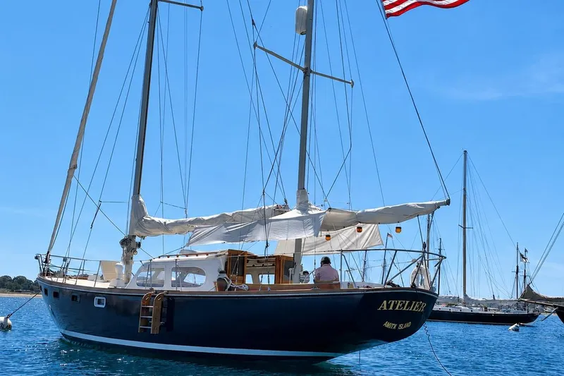 Slide: The Image of 1965 Pearson Countess 44 sailboat anchored, displaying American flag, clear blue sky. - 1