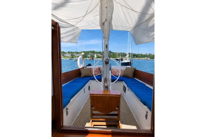 Slide: The Image of Interior view of 1965 Pearson Countess 44 sailboat with blue seating and scenic harbor backdrop. - 2