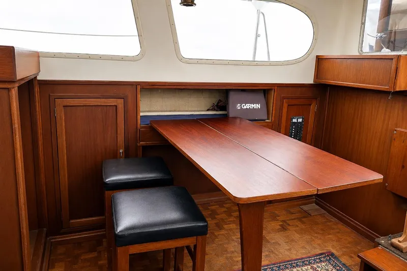 Slide: The Image of Interior of 1965 Pearson Countess 44 sailboat with wooden table and stools. - 5