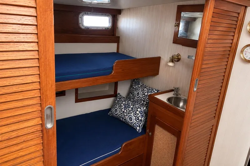 Slide: The Image of Cozy cabin interior of 1965 Pearson Countess 44 sailboat with wooden bunk beds and sink. - 6