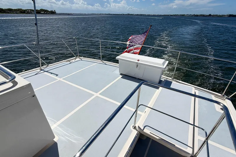 Slide: The Image of Deck view of 2018 Marlow 53E yacht with American flag, cruising on open water. - 16