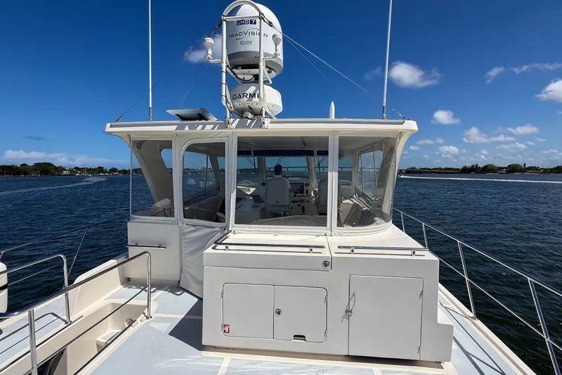 Slide: The Image of 2018 Marlow 53E yacht on water, featuring enclosed helm and navigation equipment. - 17